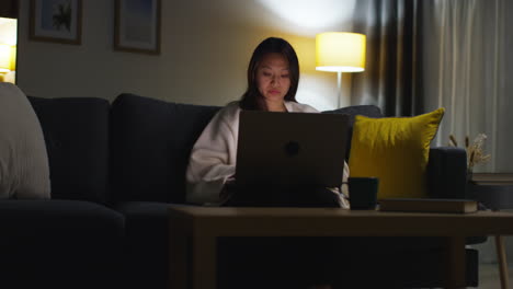 Woman-Spending-Evening-At-Home-Sitting-On-Sofa-With-Laptop-Computer-Looking-At-Social-Media-Streaming-Or-Scrolling-Online-5